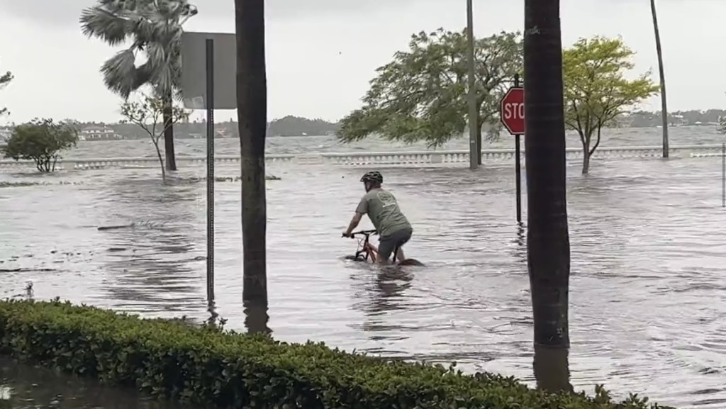 尽管佛州州长德桑蒂斯警告民众“不要做蠢事”，坦帕湾一名男子被发现在近1米深的水中坚持踩单车。 