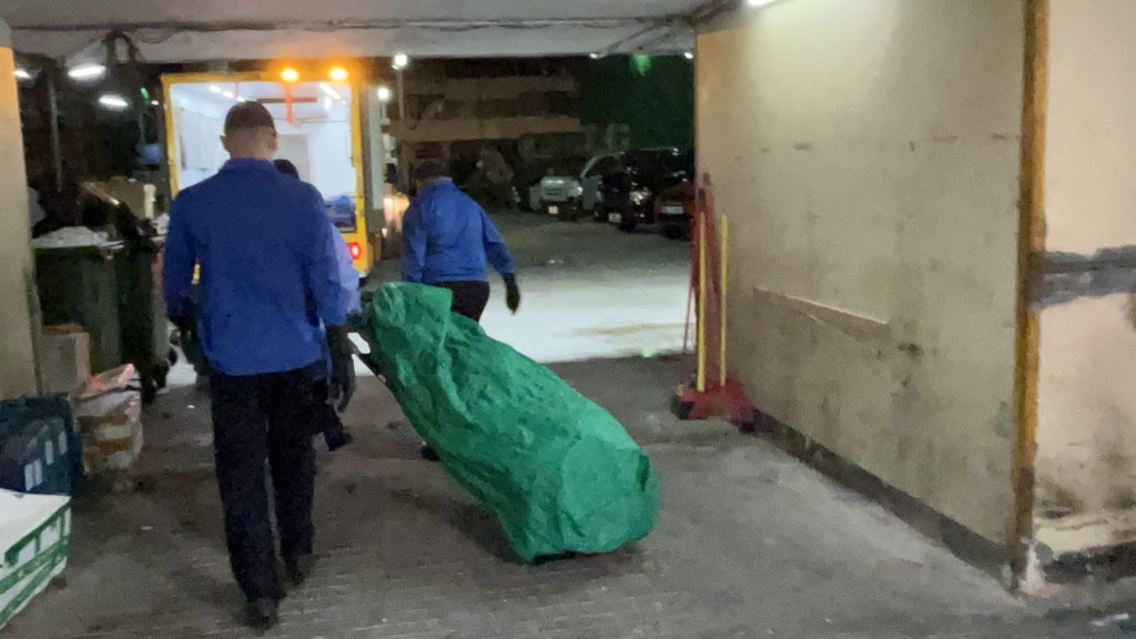 仵工从太安楼移走两名死者遗体。蔡楚辉摄