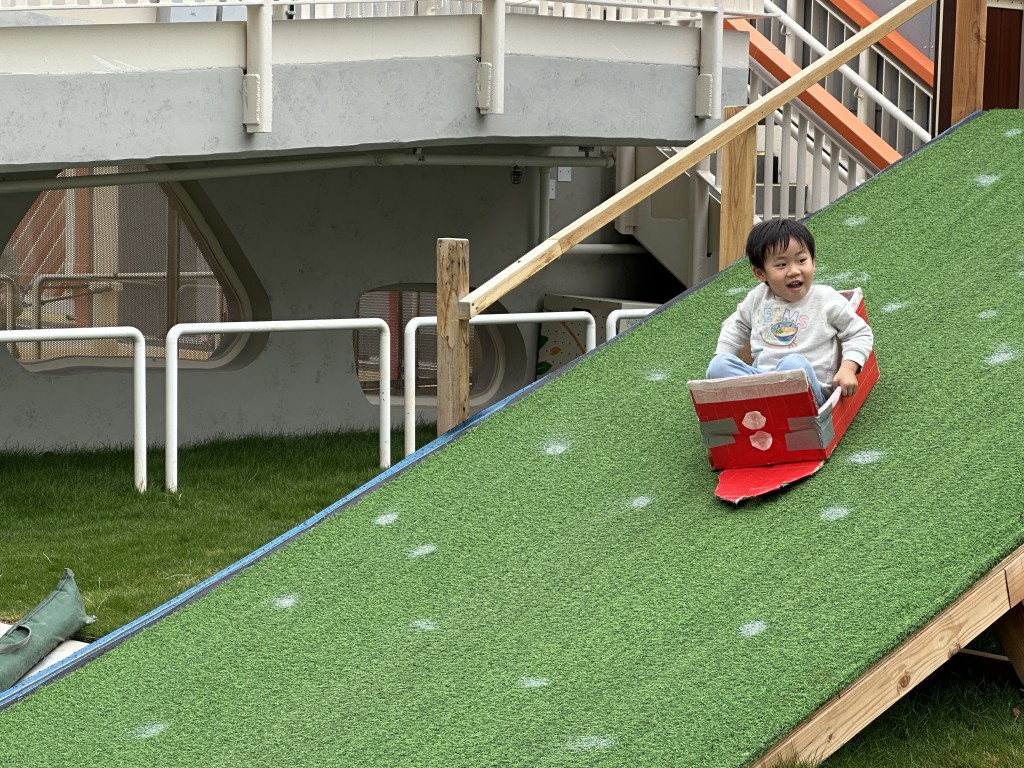 草坡滑梯,鍾意用紙皮滑又得, 愛趴着滑亦得!(圖片來源:《親子王》) 草坡滑梯,鍾意用紙皮滑又得, 愛趴着滑亦得!(圖片來源:《親子王》)