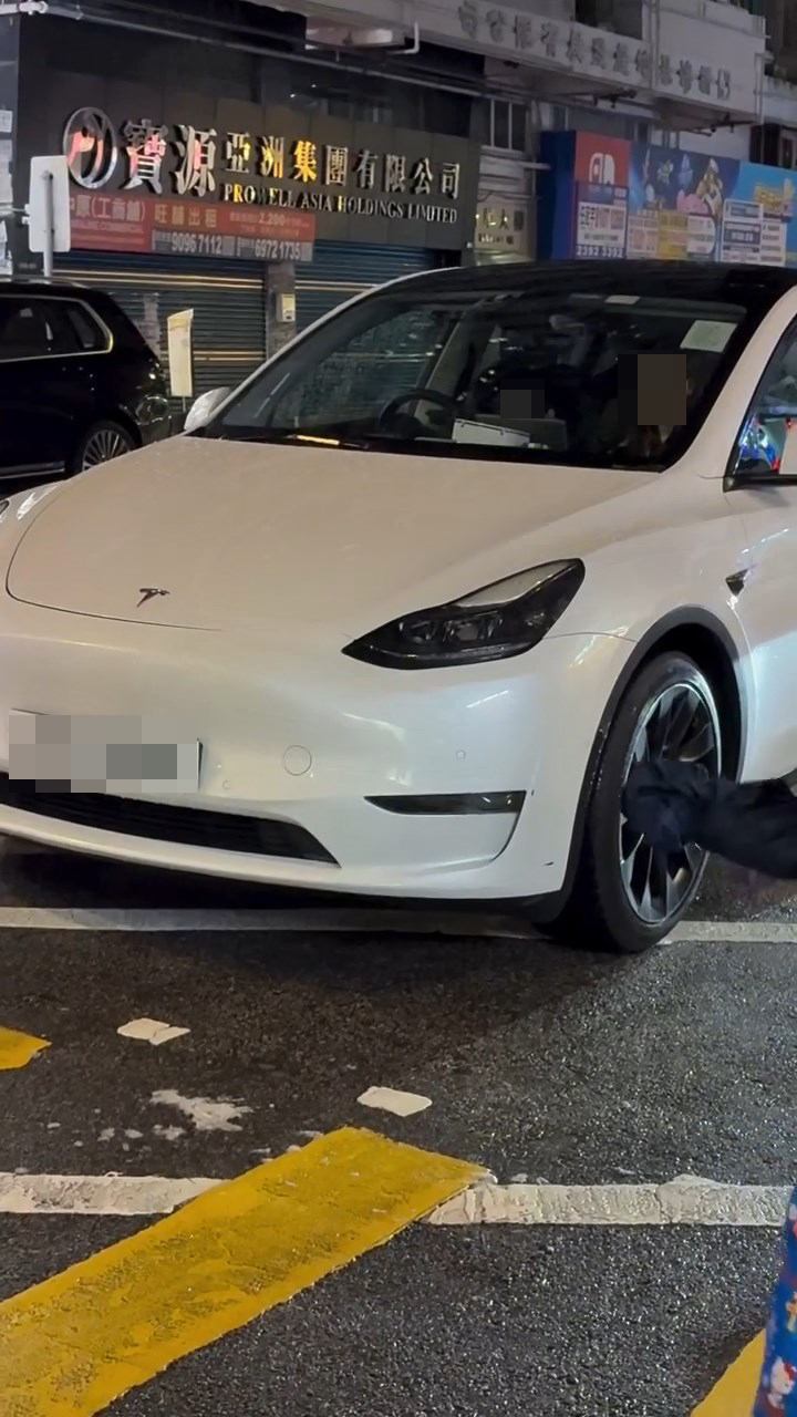 一名男童坐在白色Tesla私家車的司機位上,手握軚盤操控車輛,而旁邊的女乘客未有阻止。網上片段截圖 一名男童坐在白色Tesla私家車的司機位上,手握軚盤操控車輛,而旁邊的女乘客未有阻止。網上片段截圖
