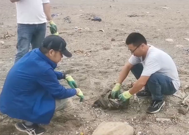 男子在長江清理垃圾時，意外找到一個手袋。 網圖