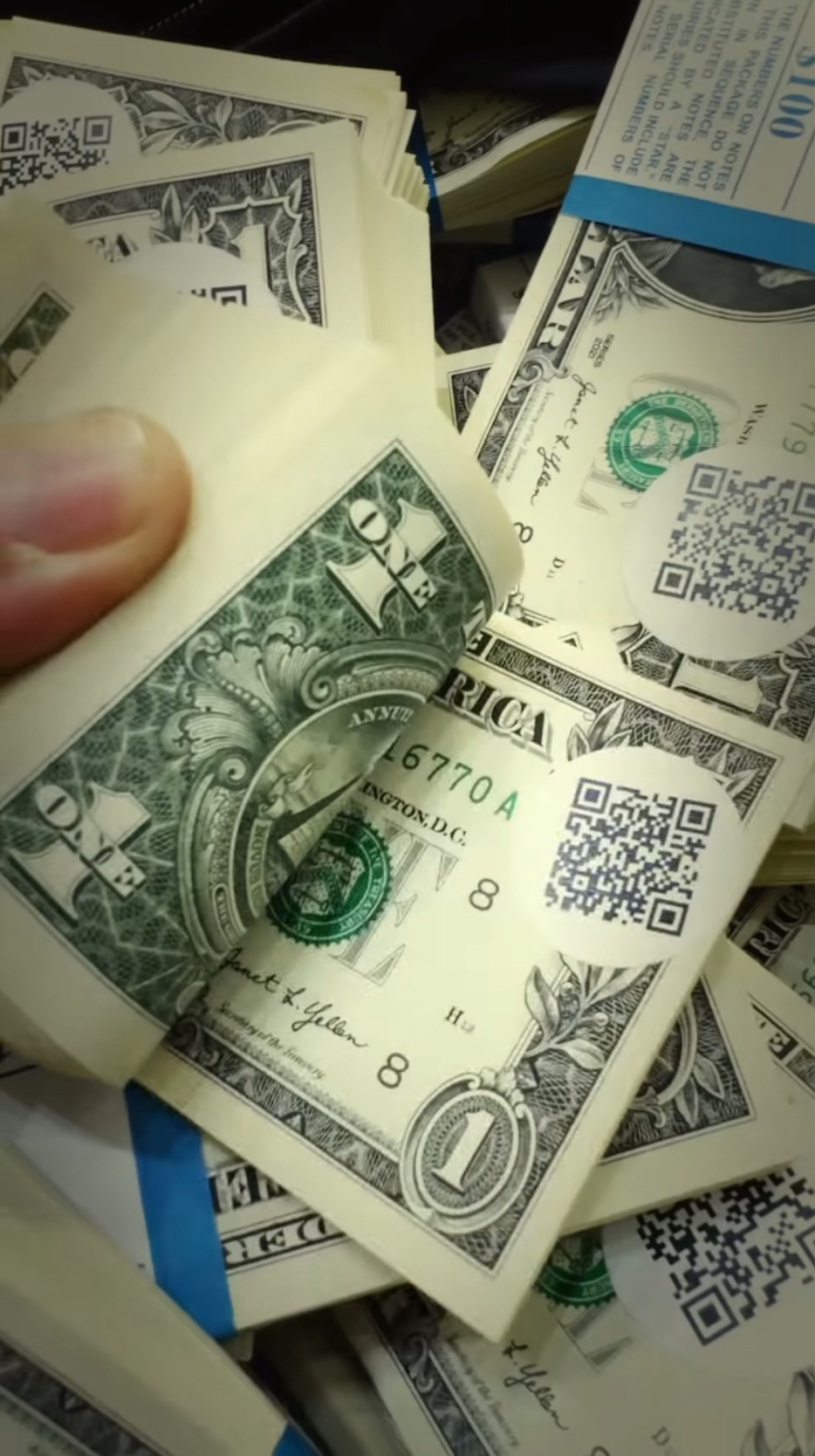 工作人员在每一张1美元纸钞都贴上QR code 。Youtube