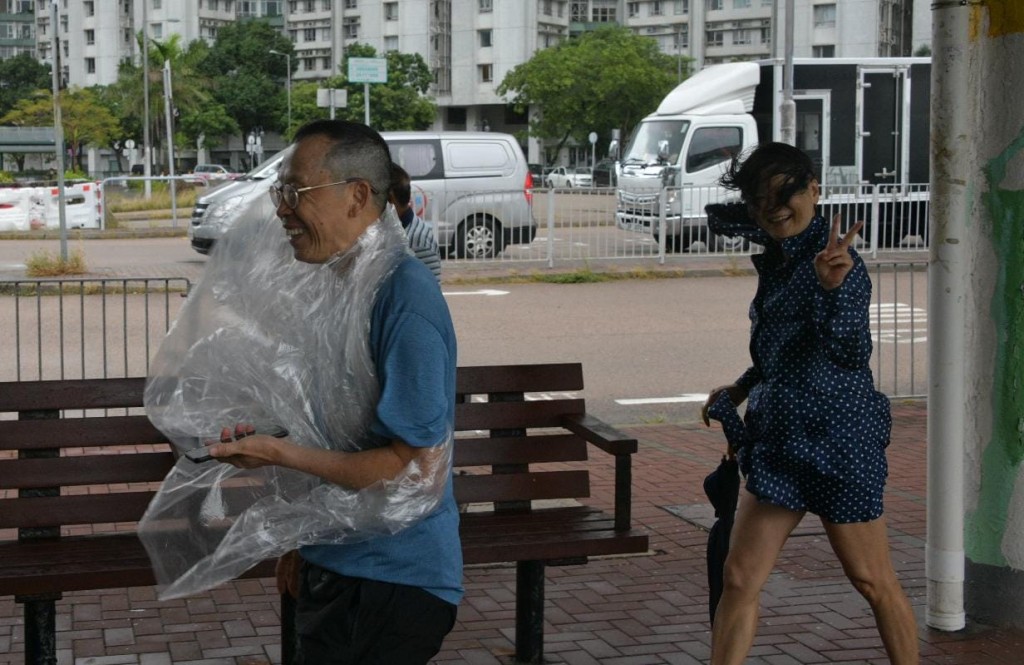 雨傘及雨褸全被吹翻市民狼狽不堪。