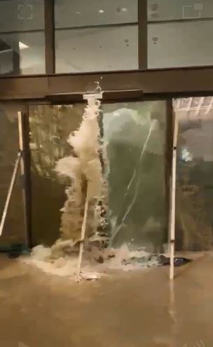 洪水衝爆酒店玻璃門。