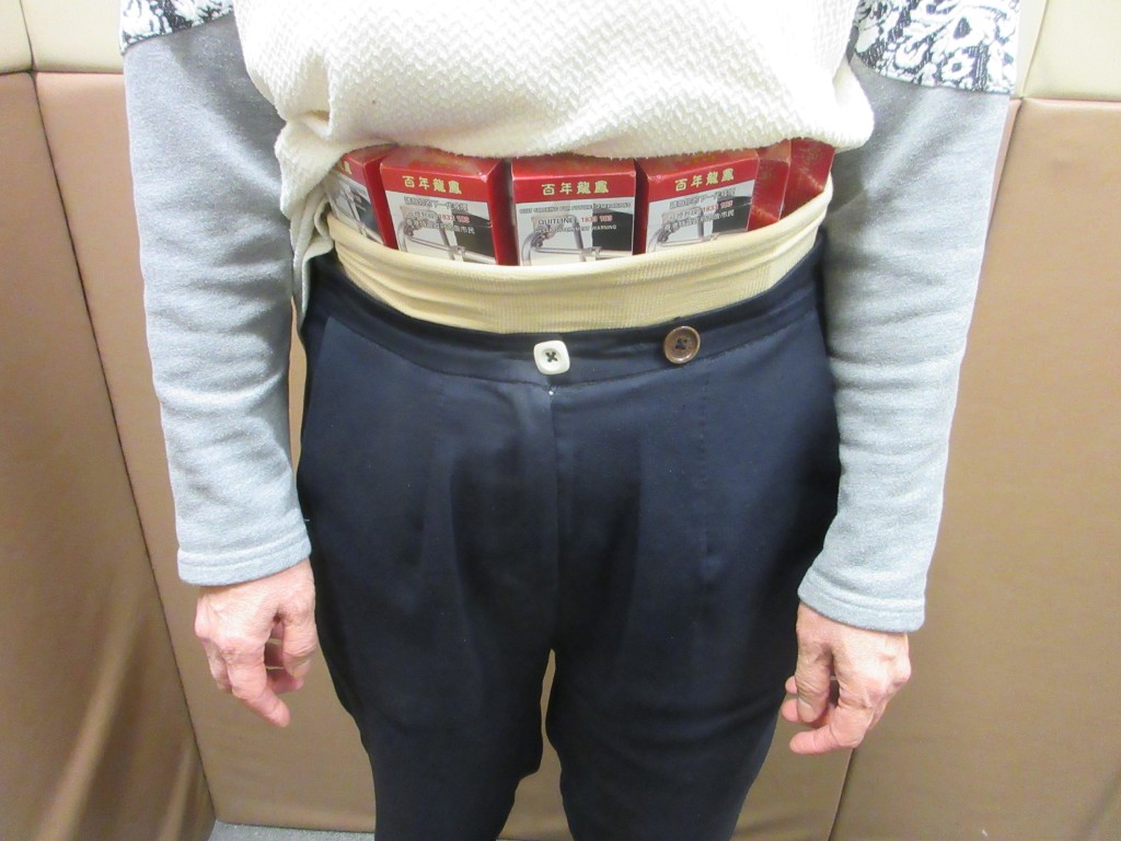 婦人在腰間收藏未完稅香煙。海關圖片