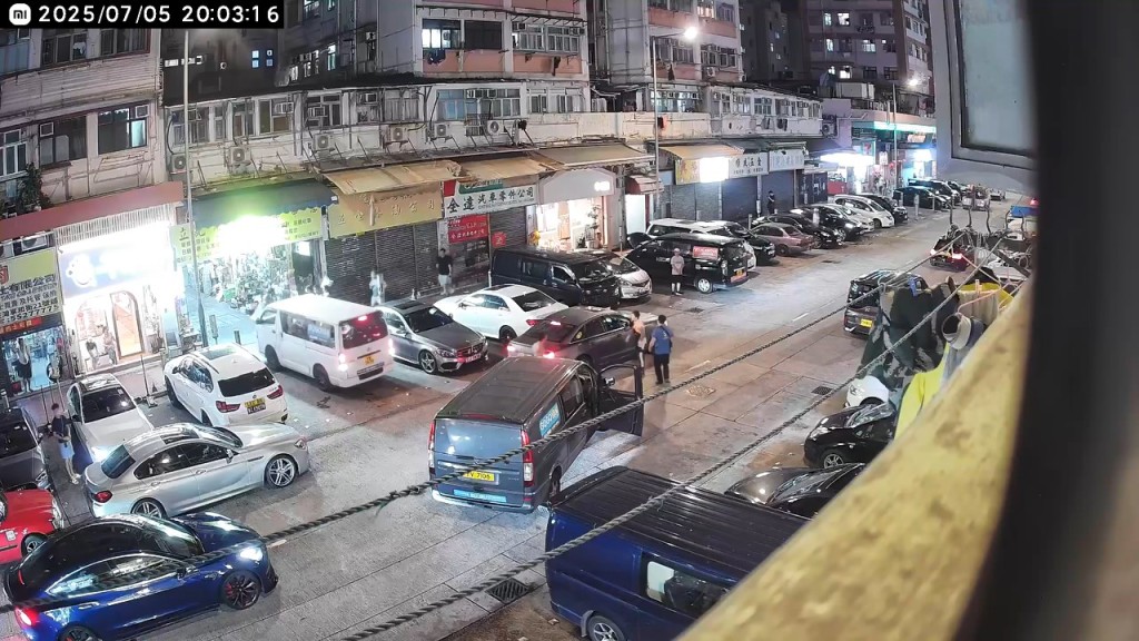 一輛深色私家車突然褪車,企圖停泊車房前的咪錶位。 一輛深色私家車突然褪車,企圖停泊車房前的咪錶位。