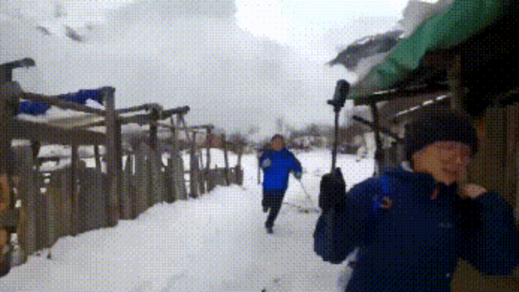 兩名男子在雪崩的反方向奔跑。網圖