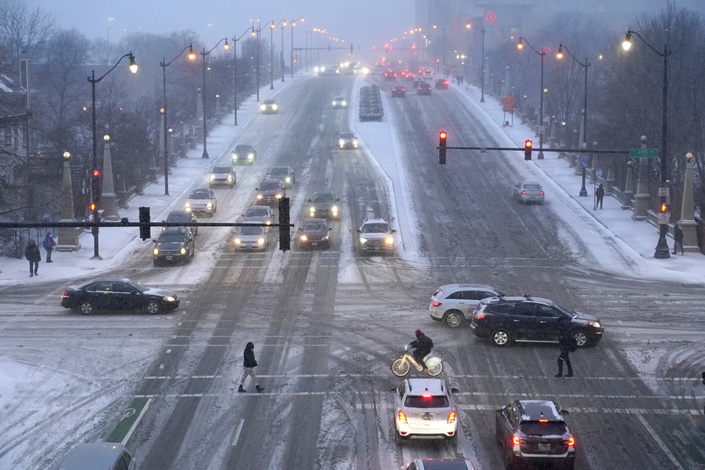 在芝加哥，冬季风暴下，行人在湿滑的街道上行走。AP