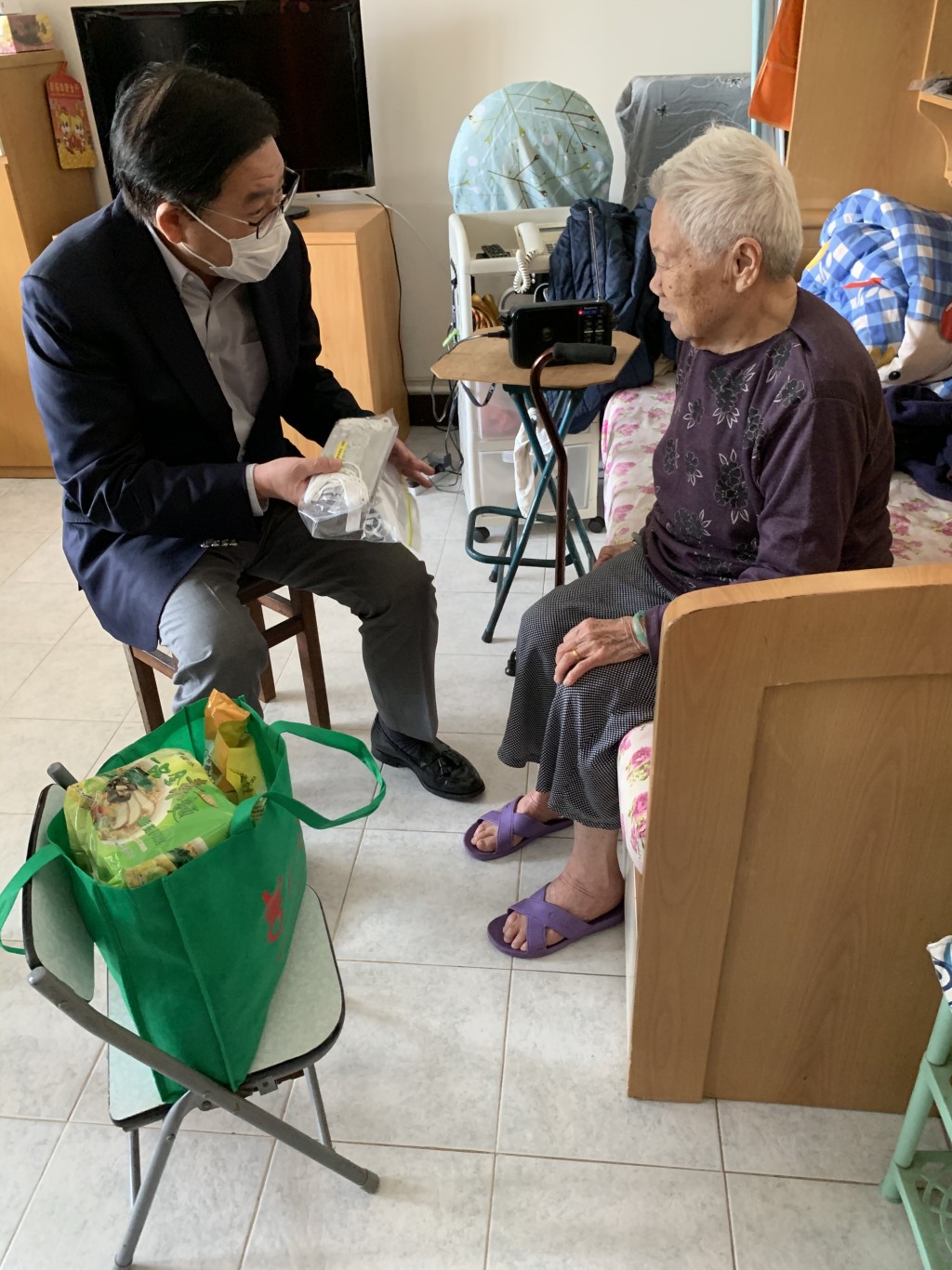 林健鋒聯同仁愛堂代表,到屯門大興邨探訪長者和派發口罩等抗疫物資。 政府圖片