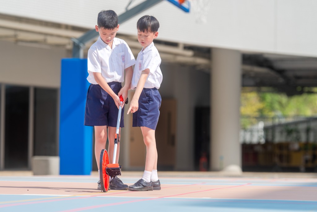学生动手量度球场长度,加深认识。(图片来源:受访学校提供) 学生动手量度球场长度,加深认识。(图片来源:受访学校提供)