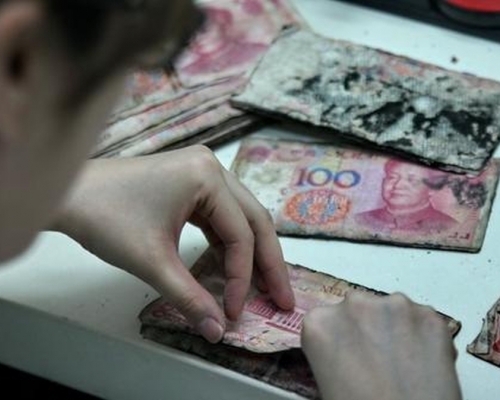 由於現金粘連嚴重,工作人員拆封時都能聽到「嘎崩脆」的聲音。(網圖)