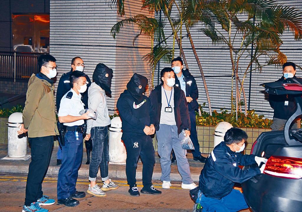 警方擎枪拘捕两名涉案男子，并押同两人协助搜车。