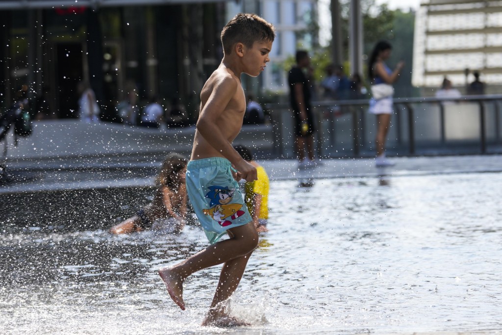 意大利米兰小童走入喷泉玩水消暑。美联社