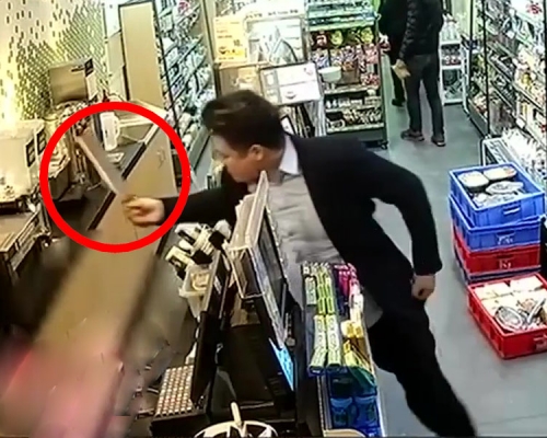 涉案男子用刀背拍店員的頭。店員見有刀,便蹲下來躲。(網圖)