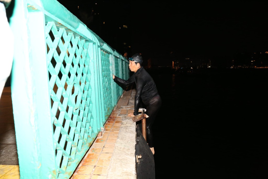 芳姐戴上泳帽及泳鏡，沿爬梯步入海中。黎志偉攝