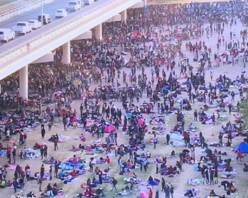大量非法移民聚集在美墨邊境的大橋下，希望進入美國。（片段截圖）