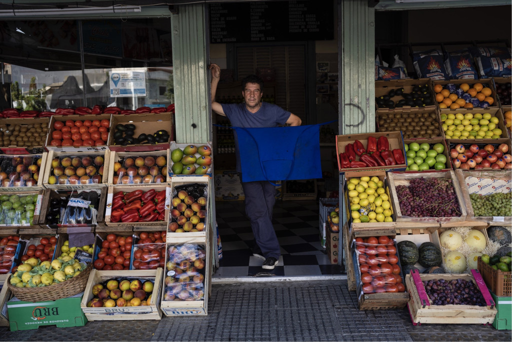 在布宜诺斯艾利斯，一个蔬果档主正在等待客人。 美联社