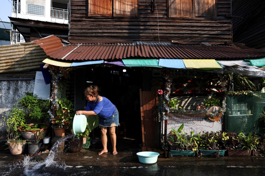泰国持续高温，民众在地面洒水降温。路透社