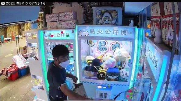 黑衫男向夾公仔機淋紅油。店主提供影片