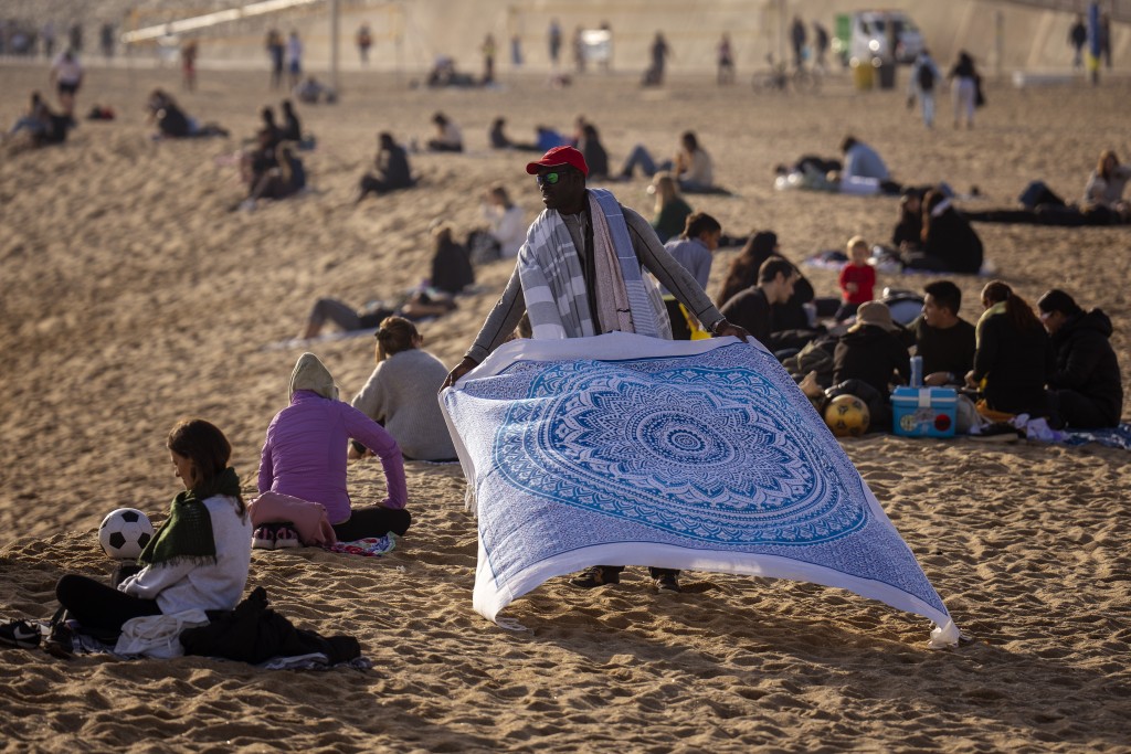 西班牙巴塞隆拿1月份出現約30度異常高溫，民眾都到沙灘消暑。美聯社