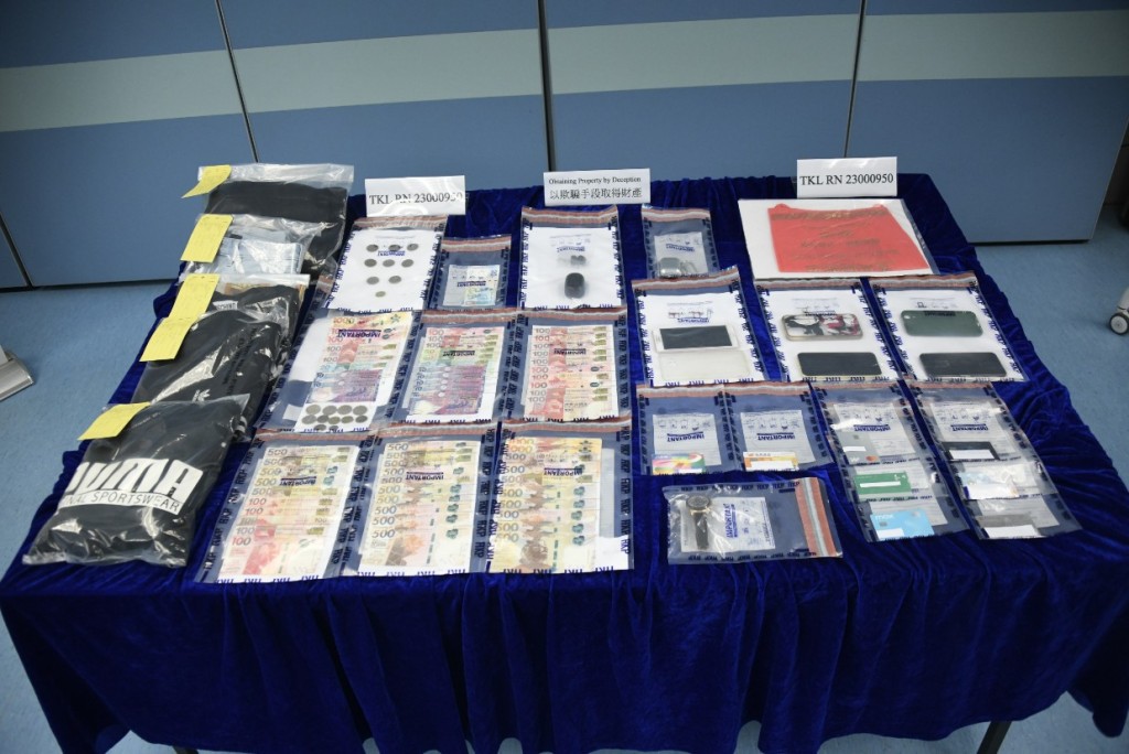 警方展示检获的现金、手机及被捕人犯案时衣物。杨伟亨摄
