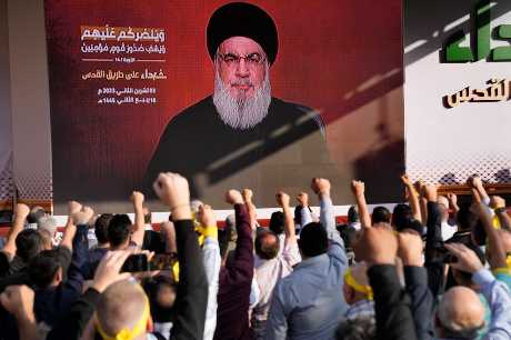 真主党领袖纳斯鲁拉周五透过视讯连结出现在贝鲁特举行的集会上，支持者举拳欢呼。美联社