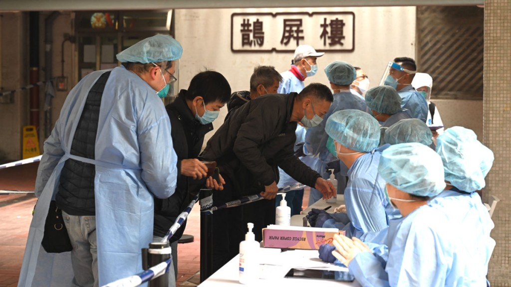 工作人員在「受限區域」內進行執法行動,檢查受限人士是否已接受強制檢測。政府圖片