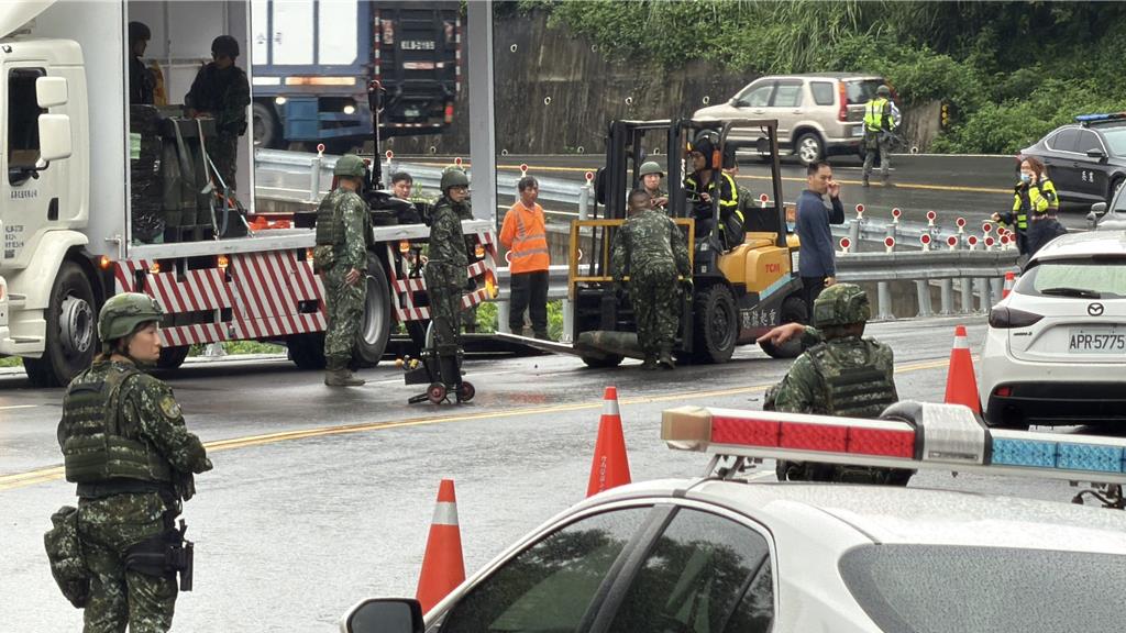 台灣軍方將跌出卡車的8寸榴彈回收。中時