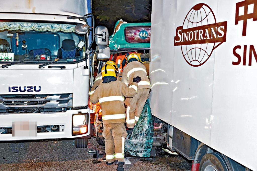 消防員動用工具撬開小巴車身將被困姓羅司機救出。 