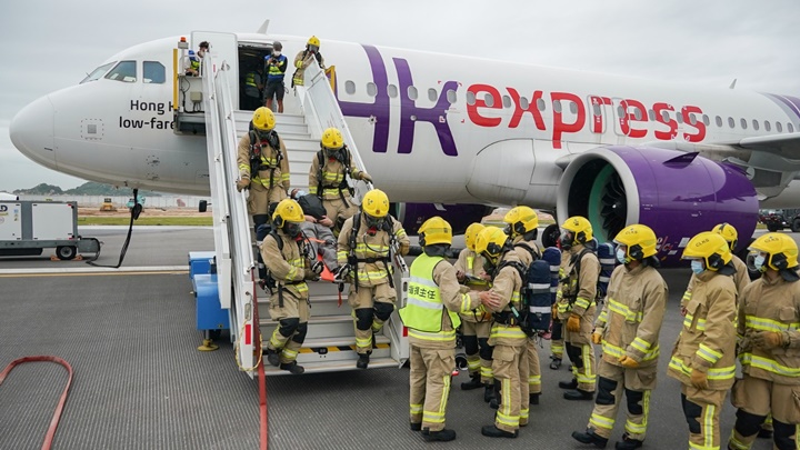 消防員模擬登上飛機救出傷者。