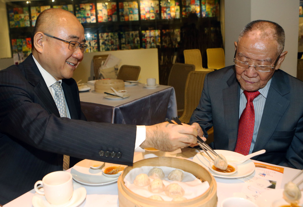鼎泰豐董事長楊紀華（左）與創辦人父親楊秉彝（右）共享自家小籠包。 中央社