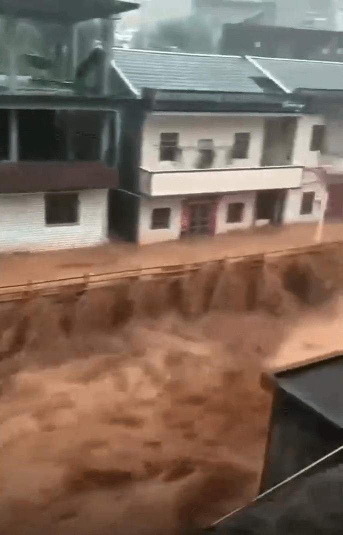 广东梅州有乡村的通道和河道在洪水下如瀑布。