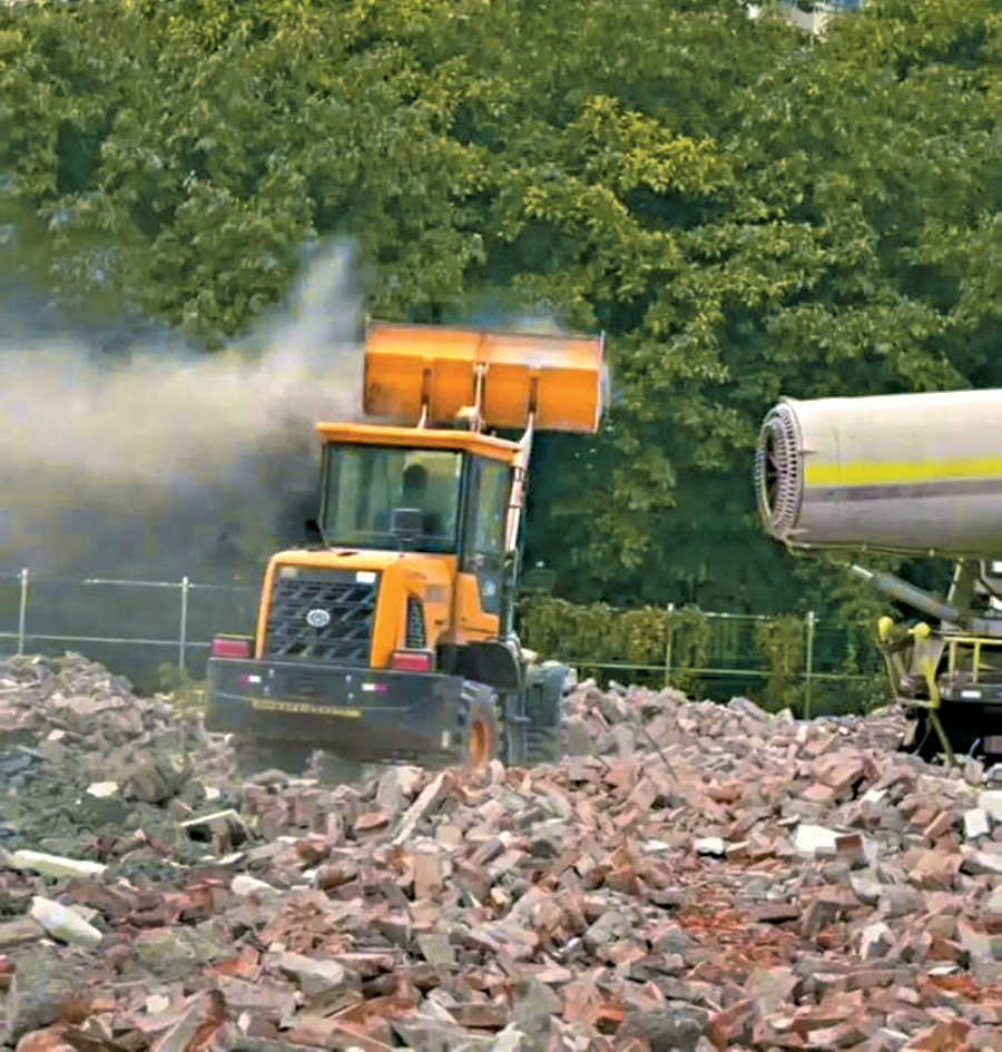拆遷現場的設備不斷向鏟車吹風，揚起沙塵。