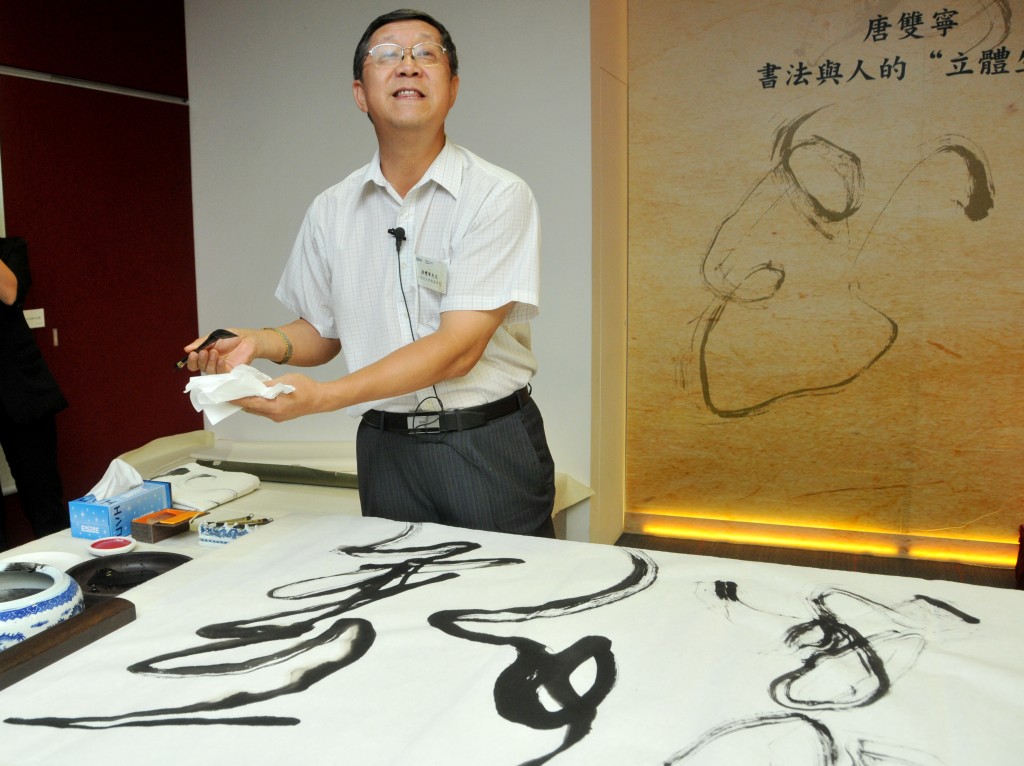 2011年唐双宁在香港城大演讲时现场表演书法。 星岛资料图