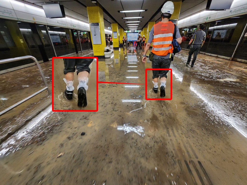 月台一片泥濘，遠處有大批工程人員正在搶修，有工程人員似在鞋中套上膠袋（紅框），以便在泥濘中行走。