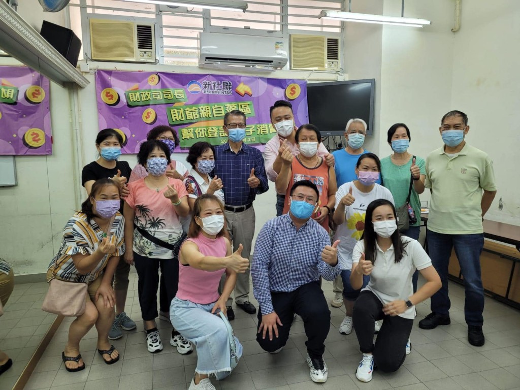 財政司司長陳茂波(深藍衫)落區協助市民登記領取電子消費券。FB圖片