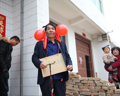 公公身上挂著写有「我要洗尿布」字样的牌子。图：腾讯