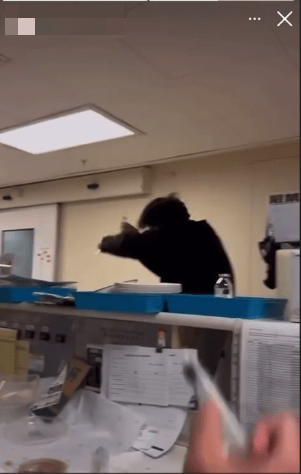 拍攝者以一支類以針筒的物品，向一名黑衣男子射水。網上影片截圖