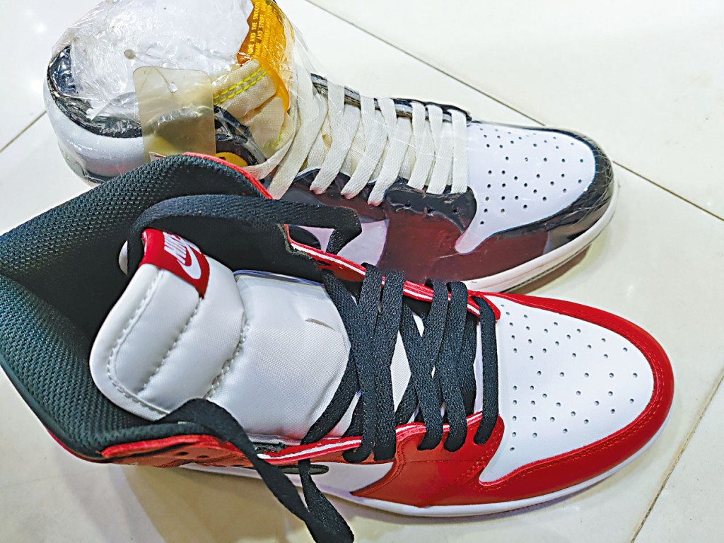 旺角「波鞋街」一店鋪負責人拿出Air Jordan系列波鞋(上),與高仿Air Jordan 1 Chicago波鞋作比對。