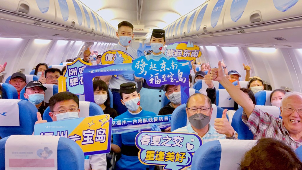 乘客乘坐福州至台北复航首航航班，与空服互动。中新社
