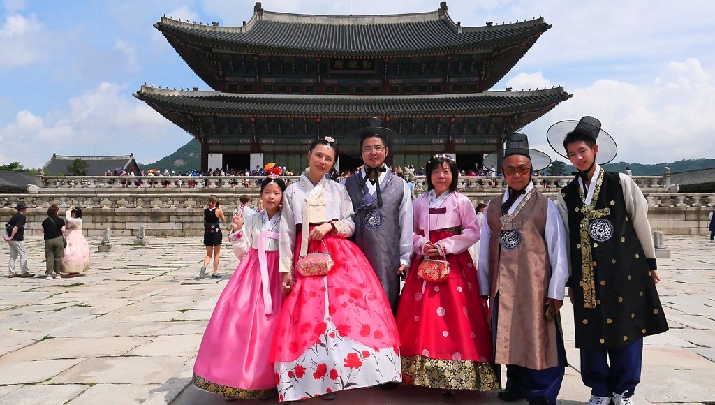 游客在韩国古建筑前穿韩服摄影留念。