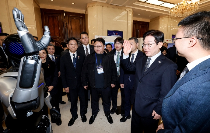 李在明上海出席中韓創新創業論壇，與國產機械人互動。 微博