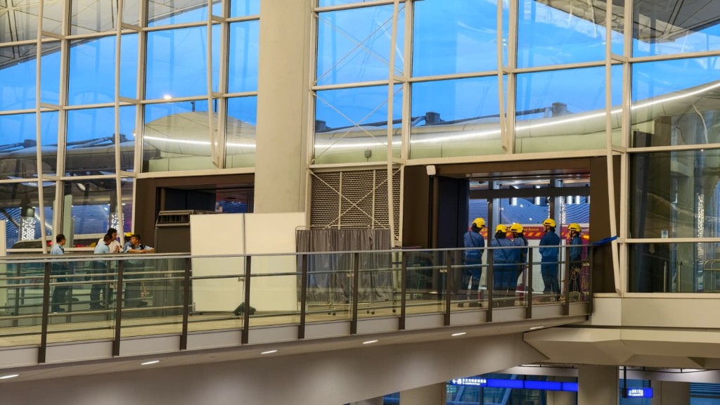 一名男子於香港國際機場一號客運大樓L7離境樓層一天橋位置危坐。黃文威攝 一名男子於香港國際機場一號客運大樓L7離境樓層一天橋位置危坐。黃文威攝