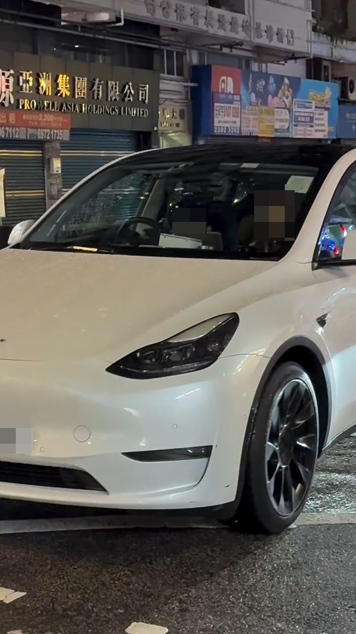 一名男童坐在白色Tesla私家車的司機位上,手握軚盤操控車輛,而旁邊的女乘客未有阻止。網上片段截圖 一名男童坐在白色Tesla私家車的司機位上,手握軚盤操控車輛,而旁邊的女乘客未有阻止。網上片段截圖