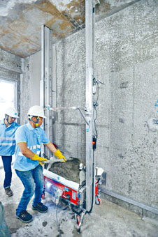 ■工人將水泥漿放上自動批盪機。