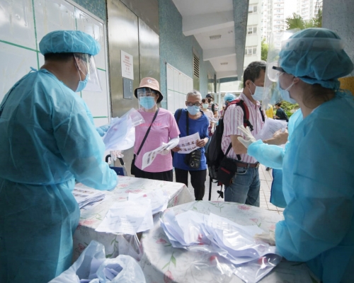 當局向慈正邨居民派樣本瓶。