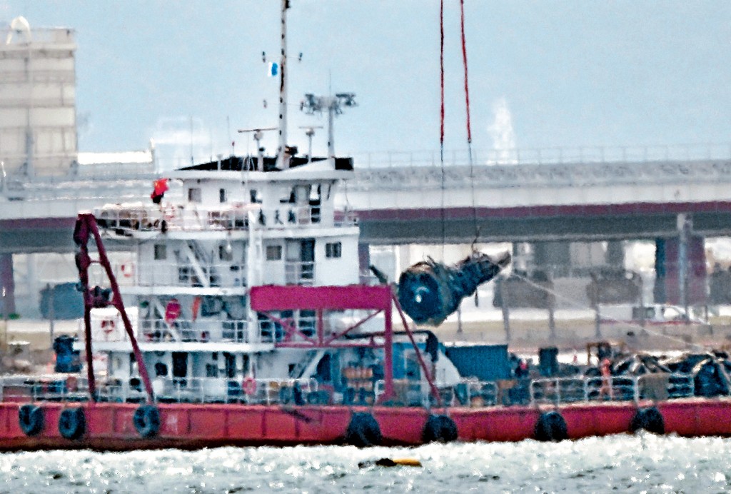 墮海貨機打撈現場，吊臂從海中打撈出疑似貨機引擎的零部件。