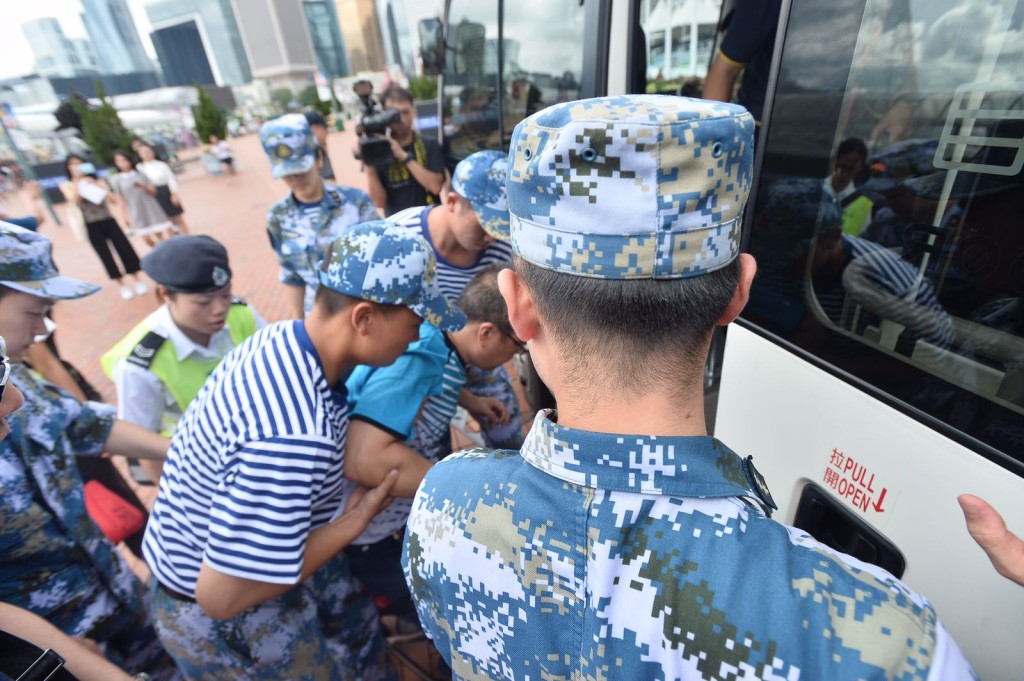 上岸後,官兵攙扶不適男子上車。