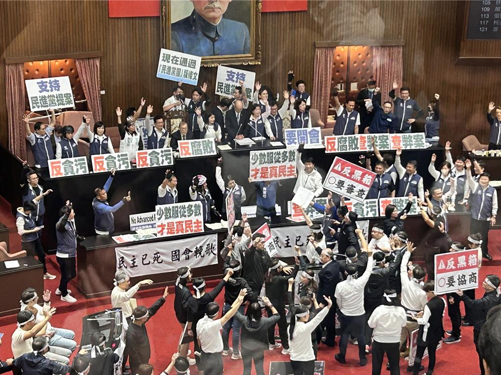 台灣立法院21日下午繼續處理藍白國會改革相關法案，民進黨不斷舉牌抗議，要求退回重審。中時