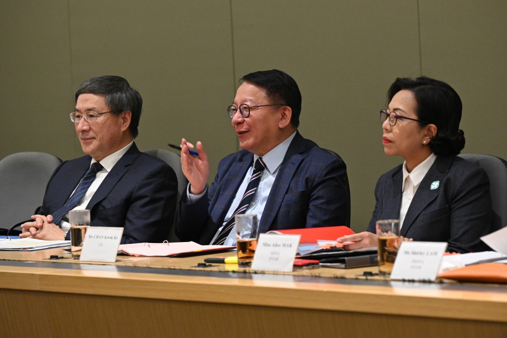陈国基（中）、卓永兴（左）和麦美娟（右）在会上与其他委员就地区事务交换意见。政府新闻处图片